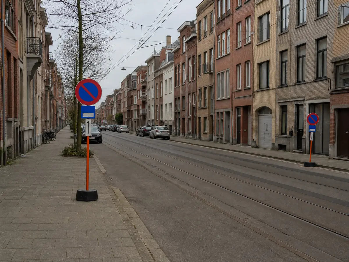 Parkeerverbodsborden naast tramsporen in een straat met appartementen in Deurne